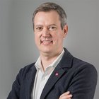 Artigianato sostenibile Ritratto di uomo sorridente con le braccia incrociate su sfondo grigio