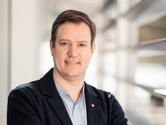 Coronavirus/Covid-19: außerordentliche Beiträge für Arbeitssuspendierungen vorgesehen Porträt eines Mannes mit verschränkten Armen in einem modernen Büro