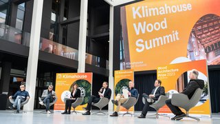 News Podiumsdiskussion bei der Klimahouse Wood Summit Veranstaltung mit sechs Teilnehmern