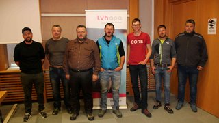 News Sieben Männer stehen in einem Raum vor einem lvhapa Banner