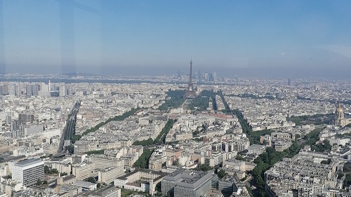 lvh-Seniorinnen und Senioren auf Frühlingsreise: Paris, mon amour! Luftaufnahme von Paris mit sichtbarem Eiffelturm und blauen Himmel