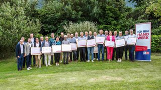 News Gruppenfoto von Personen mit Urkunden vor einem Banner Ich bin Handwerk im Freien