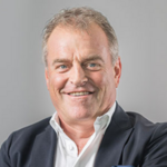 Bozen Land Portrait eines lächelnden Mannes im Anzug vor grauem Hintergrund