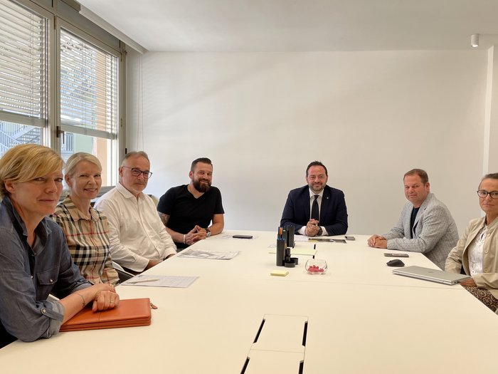 Aussprache mit Landesrat Galateo zum Thema Hausschlachtungen Sieben Personen bei einer Besprechung an einem weißen Konferenztisch in hellem Raum