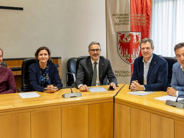 lvh bei Kompatscher: Konstruktiver Austausch Fünf Personen sitzen bei einer Sitzung an einem Konferenztisch mit Südtiroler Wappen