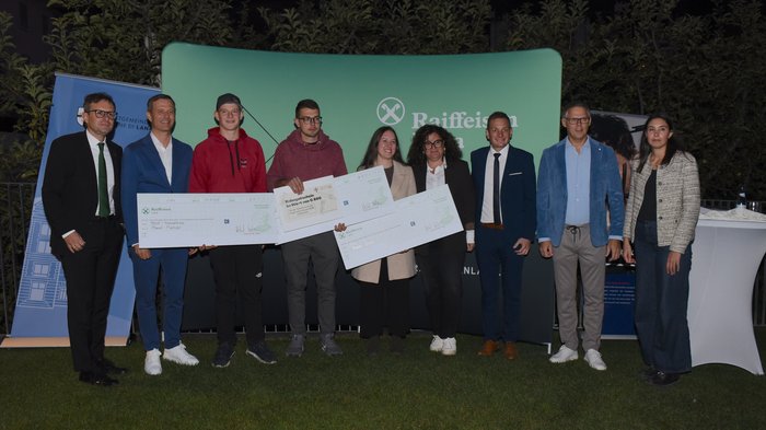 Ein starkes Zeichen für das junge Handwerk – Erfolgreiche Premiere des 1. Förderpreises Junges Handwerk in Lana Gruppenbild bei Preisverleihung mit großen Schecks und Raiffeisen Hintergrund