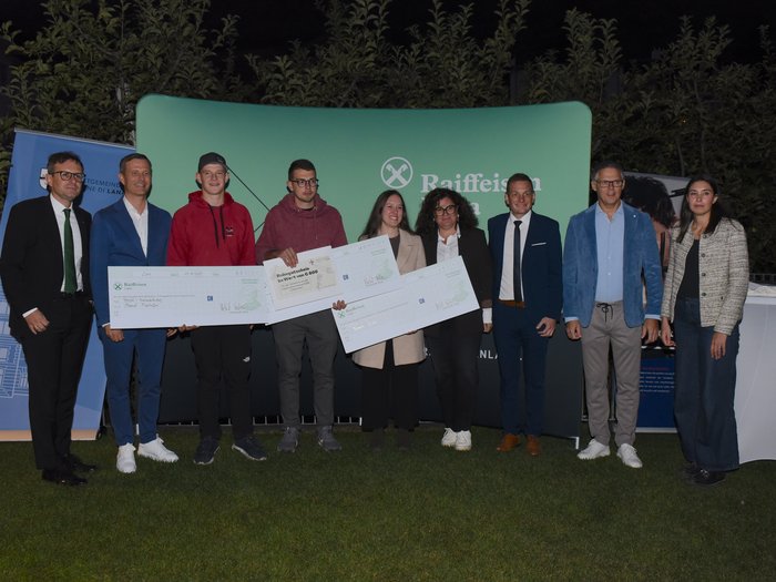Ein starkes Zeichen für das junge Handwerk – Erfolgreiche Premiere des 1. Förderpreises Junges Handwerk in Lana Gruppenbild bei Preisverleihung mit großen Schecks und Raiffeisen Hintergrund