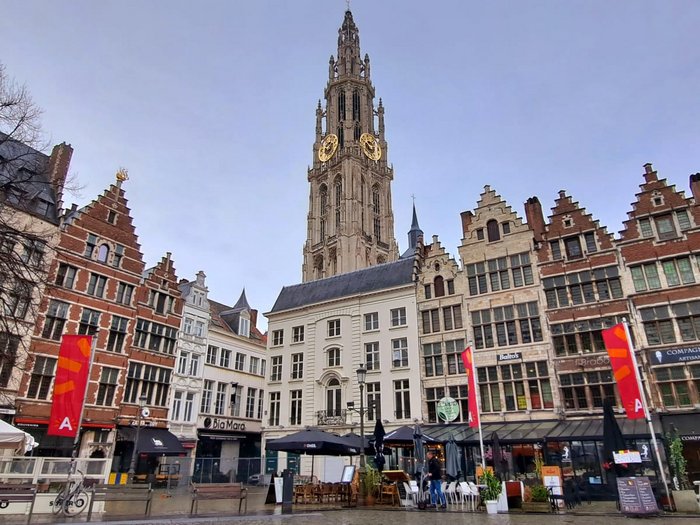 Althandwerker/innen im Herzen der Europäischen Union Historische Gebäude und Kirchturm am Platz in Antwerpen bei bewölktem Himmel