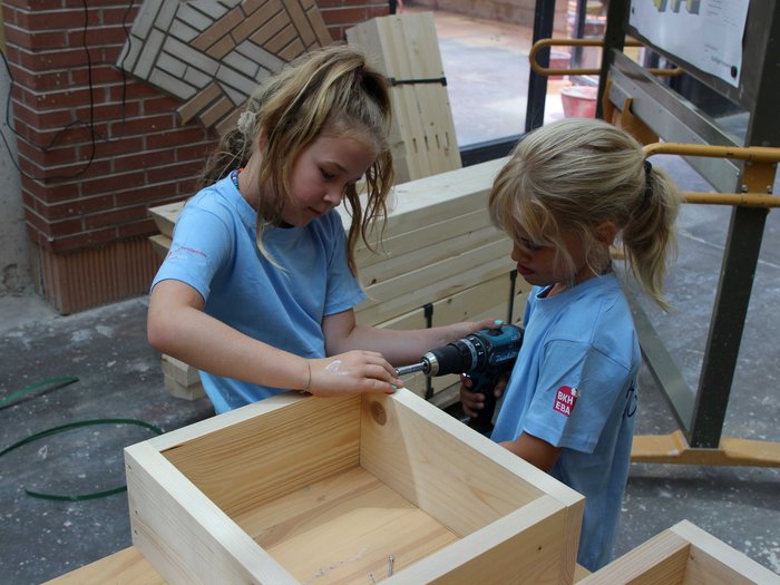 Kids-Academy 2024: Eine lehrreiche Erfahrung im Vinschgau Zwei Mädchen arbeiten gemeinsam an einem Holzprojekt mit einer Bohrmaschine