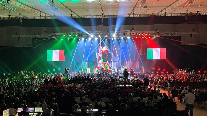 Die EuroSkills 2021 sind offiziell eröffnet Große Menschenmenge bei Veranstaltung mit italienischen Flaggen und bunten Lichtern