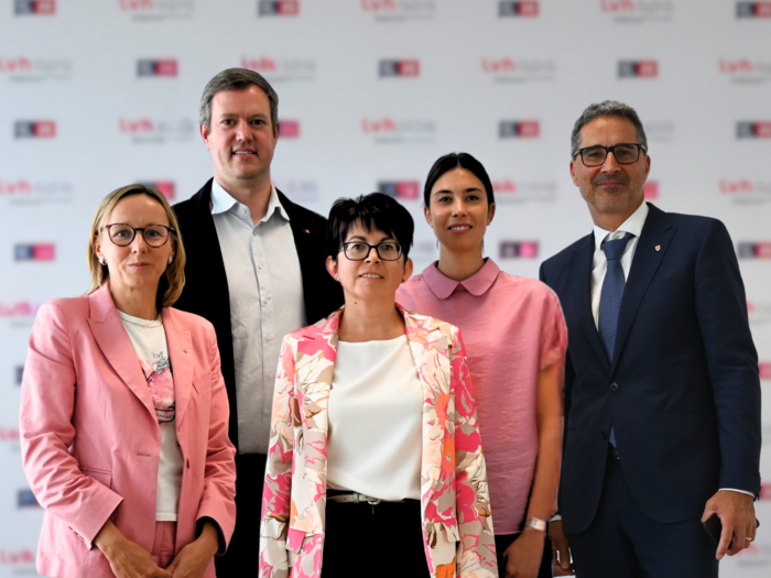 Dare un taglio alla burocrazia! Cinque persone in abiti formali rosa davanti a sfondo Lvhb