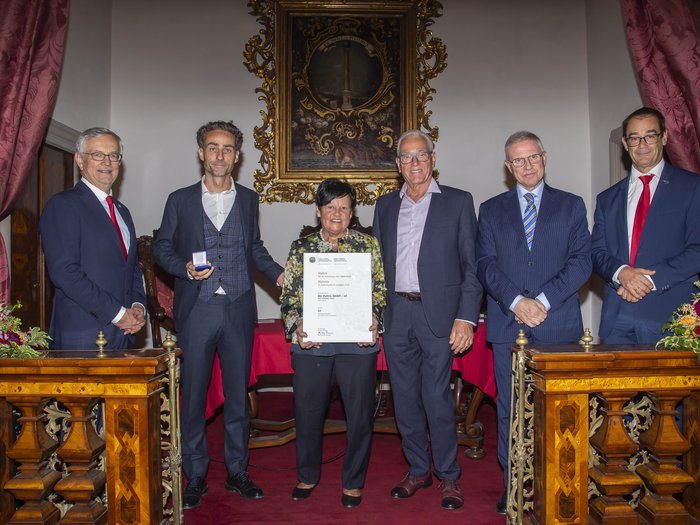 Premio Economia Alto Adige 2023: 6 aziende artigiane di lvh.apa insignite Sei persone durante una cerimonia di premiazione, una donna tiene un certificato