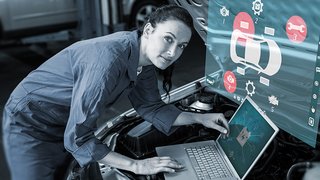 News Mechanikerin überprüft digitale Fahrzeugdiagnose mit Laptop an Auto