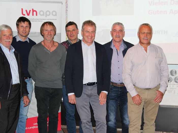 lvh-Schmiede und Schlosser blicken in die Zukunft Sieben Männer posieren vor einem Banner des Wirtschaftsverbands Handwerk und Dienstleister.