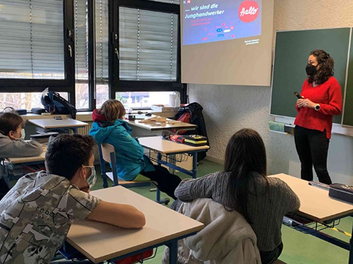 Mittelschule Leifers: Traumberufe im Handwerk und Gastgewerbe vorgestellt Lehrerin mit Maske unterrichtet Schüler im Klassenzimmer mit Präsentation