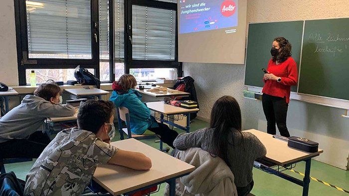 Mittelschule Leifers: Traumberufe im Handwerk und Gastgewerbe vorgestellt Lehrerin mit Maske unterrichtet Schüler im Klassenzimmer mit Präsentation