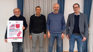 News Vier Männer stehen nebeneinander, einer hält Plakat für Tearna Wirtschaftsschau 2023