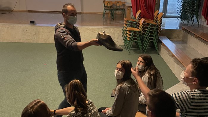 Berufe hautnah erleben Mann zeigt eine Schuhform vor sitzenden Jugendlichen in einer Unterrichtsumgebung