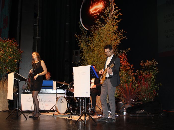 Landesversammlung des Südtiroler Handwerks Jazzband mit Sängerin, Bassist, Schlagzeuger und Keyboarder auf Bühne