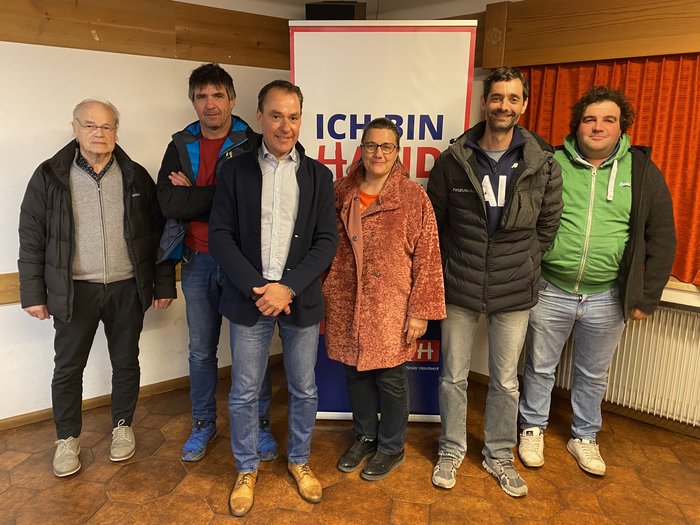 Chance Photovoltaik Gruppe von sechs Personen vor einem Ich bin Handwerk Banner in Innenraum