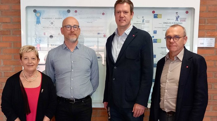 Wichtiges Treffen zwischen lvh-Spitze und der Direktion der italienischen Berufsschule Vier Personen stehen vor einer Wand mit Auszeichnungen und Urkunden