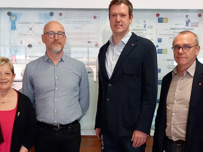 Importante incontro tra la dirigenza lvh.apa e la direzione della scuola professionale italiana Quattro persone in piedi davanti a una parete con premi e certificati