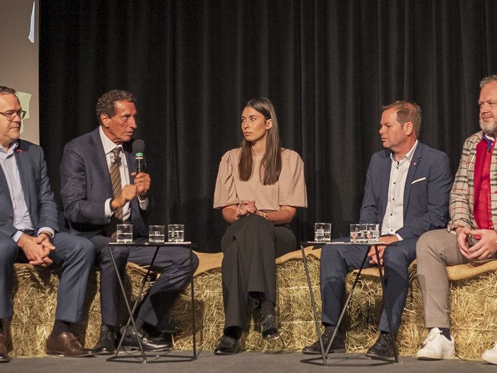 Tag des Handwerks - Jugend als Schlüssel für unsere Zukunft Fünf Personen diskutieren bei einer Veranstaltung, sitzen auf Strohballen mit Mikrofon