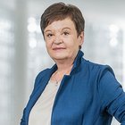 Das Nachhaltigkeitslabel Südtirol Porträt einer älteren Frau mit blauem Blazer vor unscharfem Hintergrund