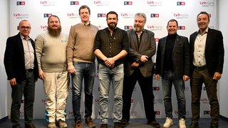 News Sieben Männer stehen vor einer lvh apa und Generation H Wand für ein Gruppenfoto