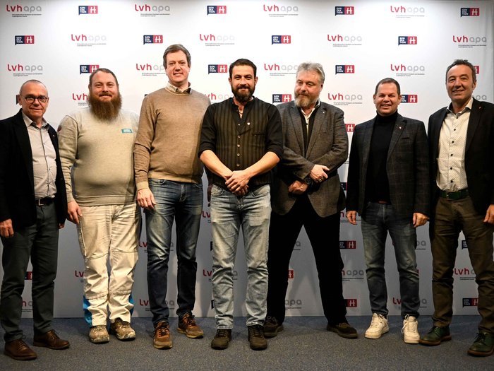 Primo confronto con il consigliere provinciale Sette uomini in piedi davanti a una parete con loghi lvh apa e Generation H per foto di gruppo