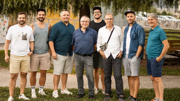 Aperitivo del Gruppo Media al Salewa-Bivac Gruppo di otto uomini posa davanti a un grande albero nel parco