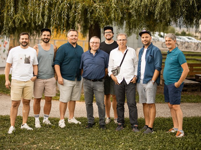 Aperitivo del Gruppo Media al Salewa-Bivac Gruppo di otto uomini posa davanti a un grande albero nel parco