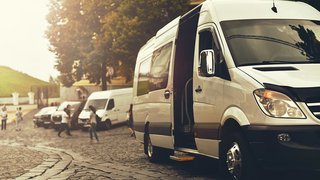 News Weiße Transporter geparkt auf gepflasterter Straße bei Sonnenuntergang