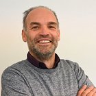 Warentransporteure Lächelnder Mann mit grauem Pullover vor weißem Hintergrund