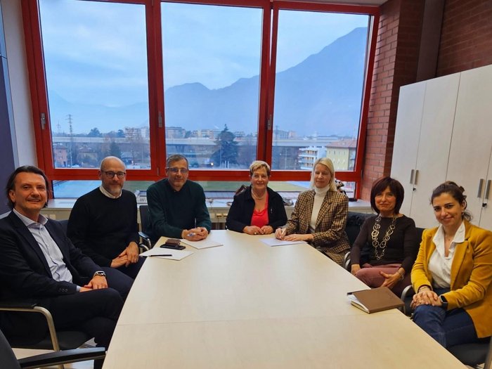 Formazione Professionale: una rete forte a sostegno dell’apprendistato Gruppo di sette persone sedute intorno a un tavolo in una riunione in ufficio con grande finestra