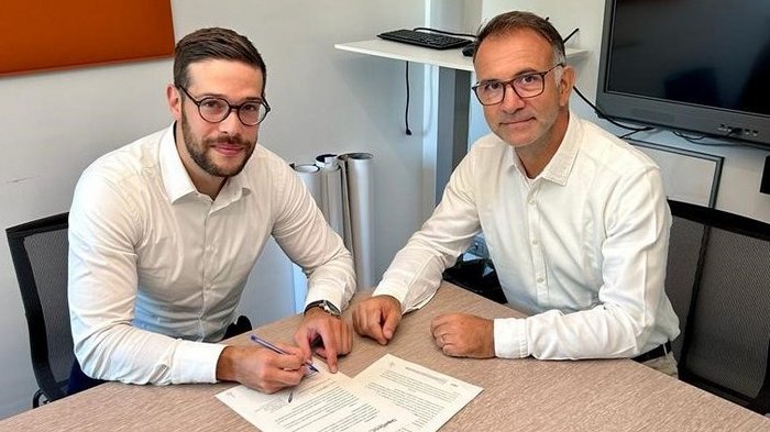 Accordo tra Potenza Assicurazioni e KSM Due uomini firmano documenti a un tavolo in un ufficio
