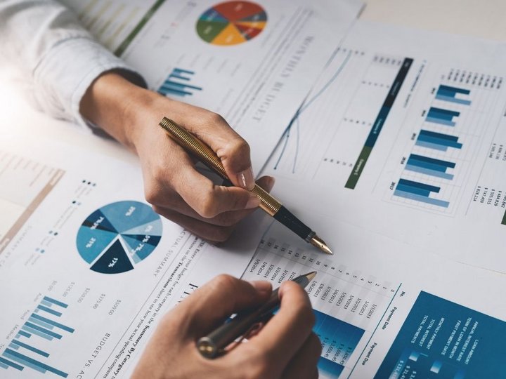 Consulenza fiscale, contabilità e calcolo della busta paga Persona analizza rapporti finanziari con grafici e tabelle