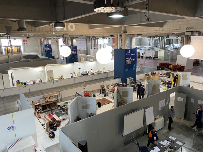 Anpfiff für WorldSkills in Bozen Blick auf eine Werkstatt mit Bau- und Fliesenarbeitsbereichen in einer Industriehalle