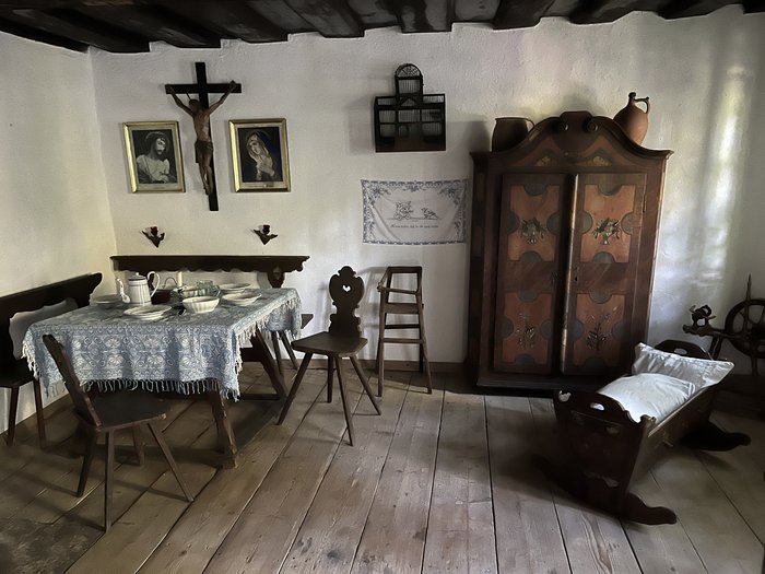 Althandwerker/innen unterwegs: Rundfahrt Weinviertel Traditionelles Bauernzimmer mit Holzmöbeln, Kreuz und Kinderwiege