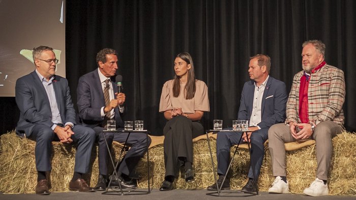 Tag des Handwerks - Jugend als Schlüssel für unsere Zukunft Fünf Personen diskutieren bei einer Veranstaltung, sitzen auf Strohballen mit Mikrofon