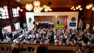 News Große Versammlung mit Menschen, die bei einem Konzert und Essen in einer Halle teilnehmen