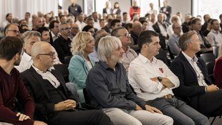 News Publikum hört aufmerksam einer Präsentation in einem Konferenzraum zu