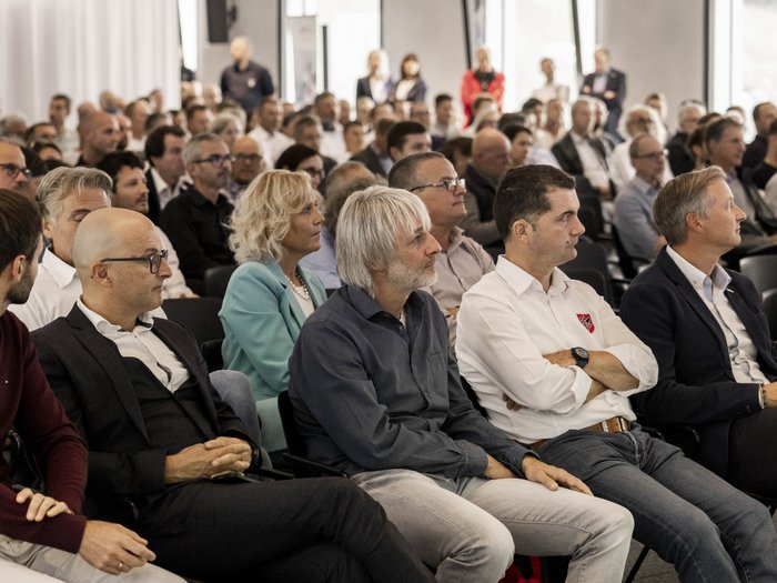 Baukongress 2025: Zukunft bauen durch Kooperation Publikum hört aufmerksam einer Präsentation in einem Konferenzraum zu