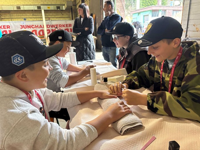 Handwerk hautnah: SkillsDay begeistert im Eggental Kinder erhalten Maniküre bei einer Veranstaltung mit Betreuern im Hintergrund