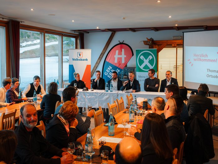 Successo della riunione comunale del gruppo lvh.apa a Dobbiaco: un anno ricco di impegno e collaborazione Persone in riunione con relatore e presentazione in una sala