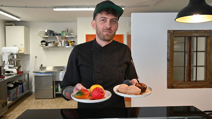 Scuola media di Colle Isarco: fare esperienza pratica delle professioni Cuoco che tiene due piatti con cioccolatini colorati in cucina