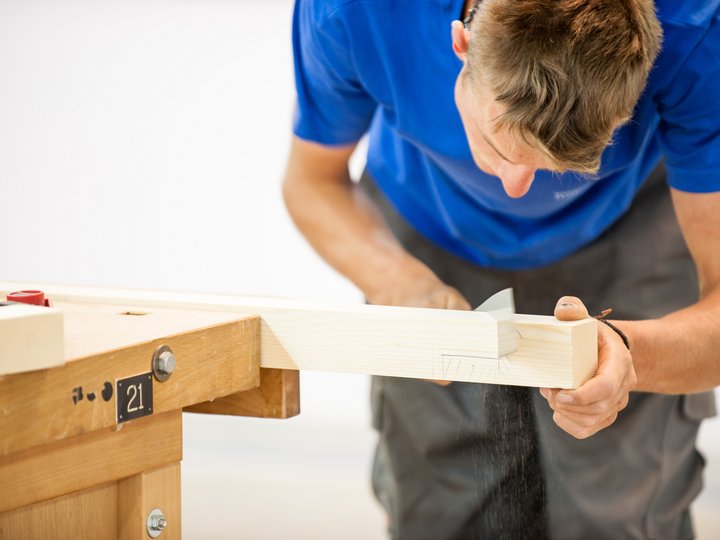 Costruttori in legno e carpentieri Uomo che lavora un pezzo di legno con pialla a mano su banco da lavoro
