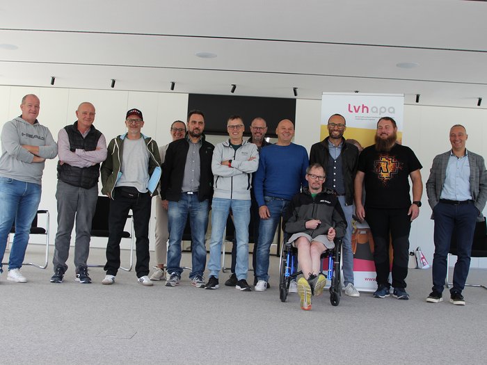 Die Teilnehmer:innen der Jahresversammlung von ECO-Südtirol – Foto: © lvh.apa Gruppenfoto von zwölf Personen in einem modernen Raum, darunter eine Person im Rollstuhl