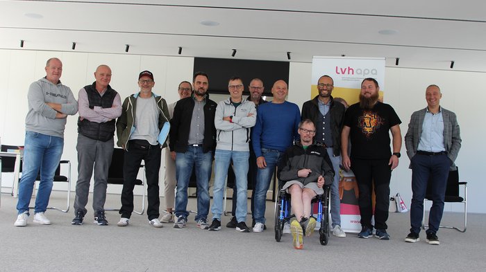 Die Teilnehmer:innen der Jahresversammlung von ECO-Südtirol – Foto: © lvh.apa Gruppenfoto von zwölf Personen in einem modernen Raum, darunter eine Person im Rollstuhl