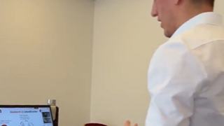 News Mann mit Headset hält Videokonferenz am Laptop in Büro